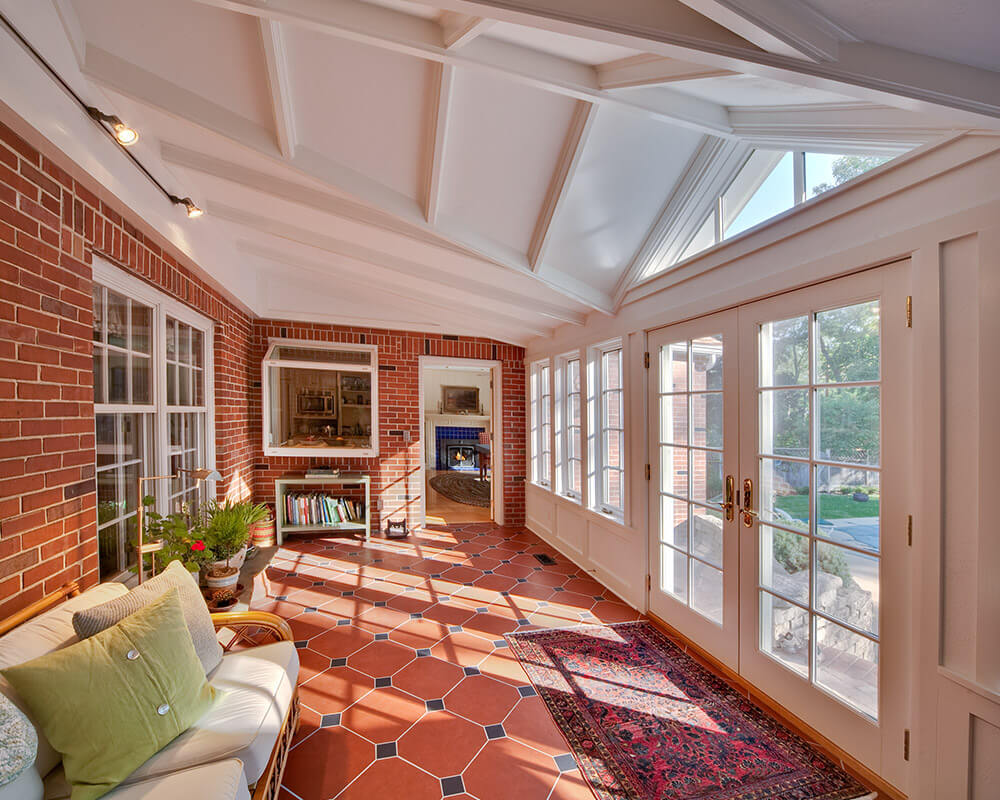 Home addition of a sunroom adds indoor-outdoor space to the rear of a traditional home in Madison.