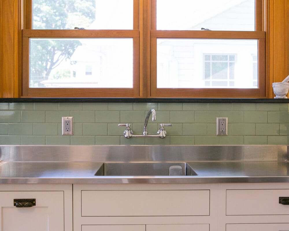 Kitchen remodel with local granite countertop and window ledge, custom stainless steel sink, and wall-mounted faucet by TDS Design Build in Madison, WI