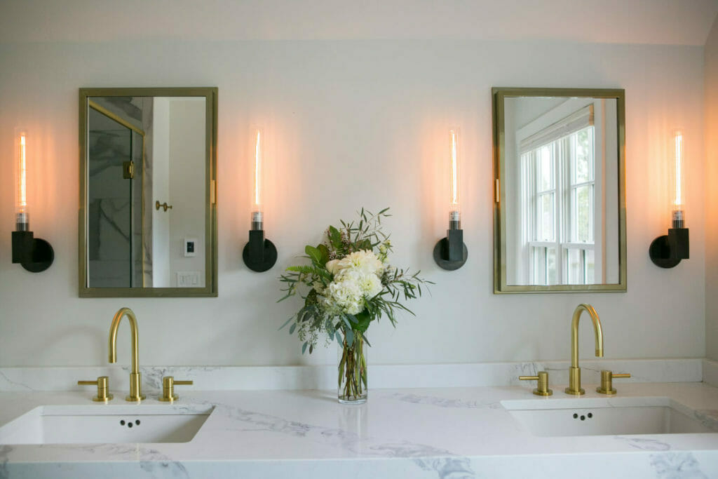 Engineered quartz countertop with modern brass fixtures for a contemporary and sophisticated ensuite bathroom remodel in Maple Bluff, Wisconsin by TDS Design Build.