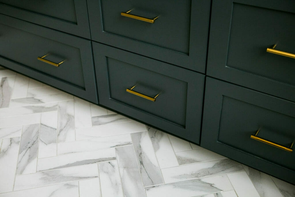 Ensuite bathroom remodel with painted Woodharbor cabinets and marble herringbone floor tile in Maple Bluff, Wisconsin by TDS Design Build.