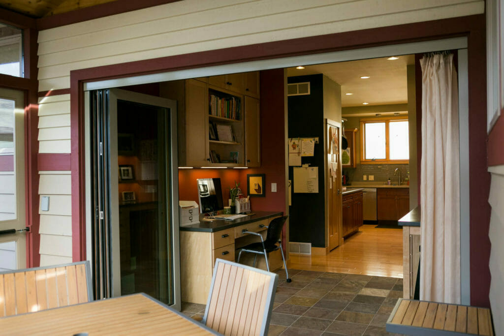 An addition of a screen porch with a full-length accordion door that opens up the family craft room in Middleton, WI by TDS Design Build.