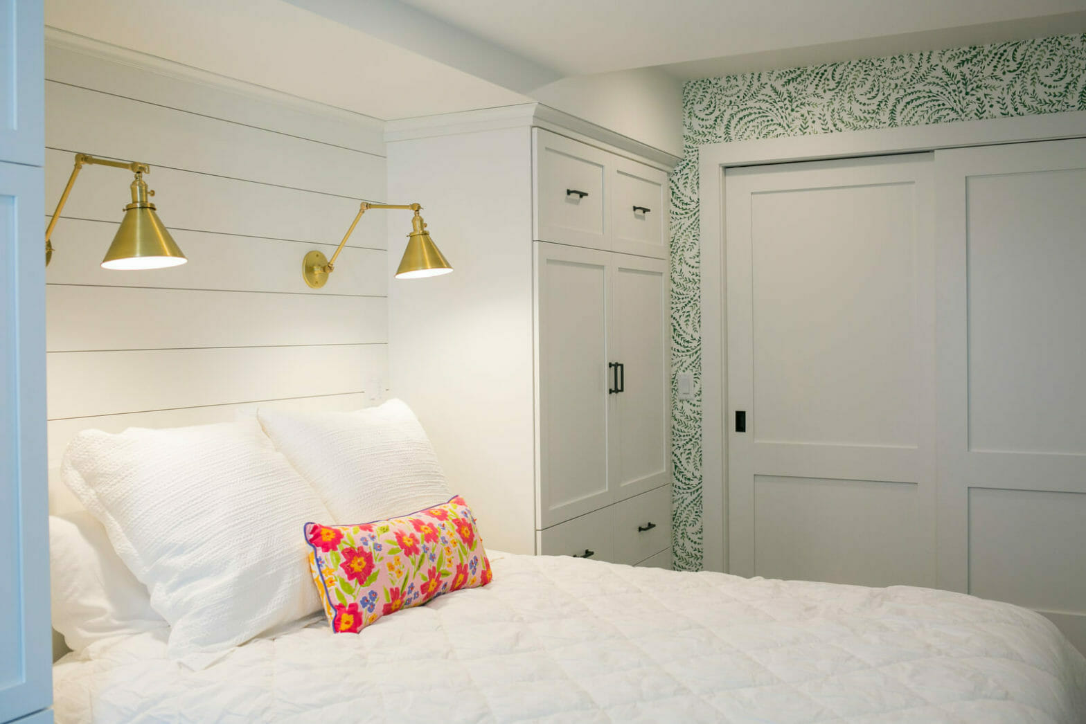 Lower level remodel that includes a guest suite with many beautiful details: wallpaper, brass reading lights, and custom cabinets. By TDS Design Build of Madison, Wisconsin.