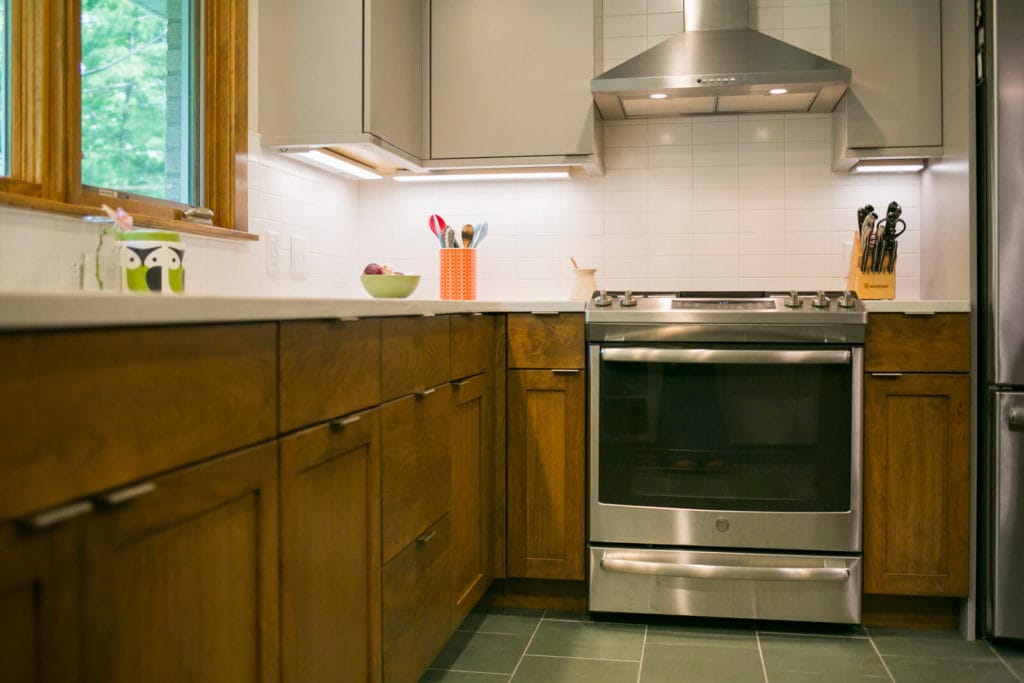 Woodharbor walnut lower cabinets and painted upper cabinets installed in a near-west Madison Wisconsin kitchen remodel by TDS Custom Construction.