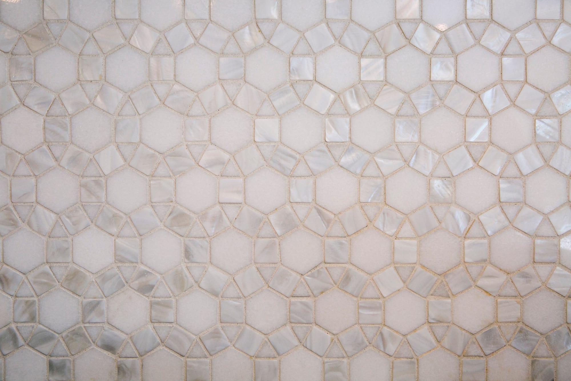 Hexagonal marble tiles arranged in a geometric pattern, featuring a soft, neutral color palette.